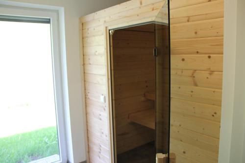 a shower in a room with a wooden wall at Bergblick-Planai - 5 Schlafzimmer plus eigene Sauna in Schladming