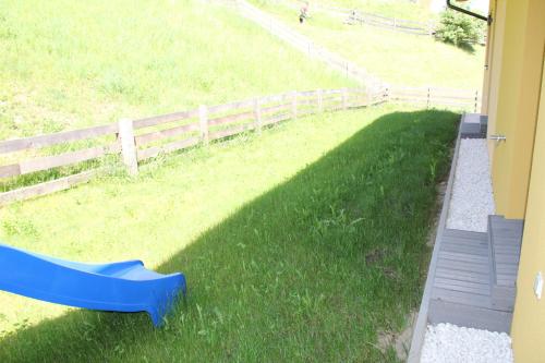 a blue slide in the grass next to a fence at Bergblick-Planai - 5 Schlafzimmer plus eigene Sauna in Schladming