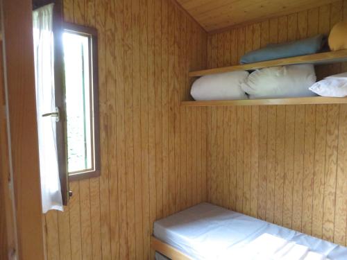 a small room with a bed and a window at Aire Du Verger in Palluau