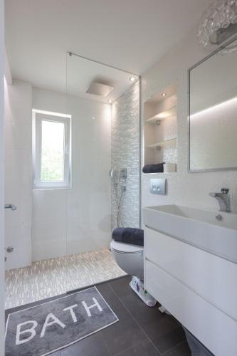 a bathroom with a toilet and a sink and a mirror at Villa Vintage & Modern in Tučepi