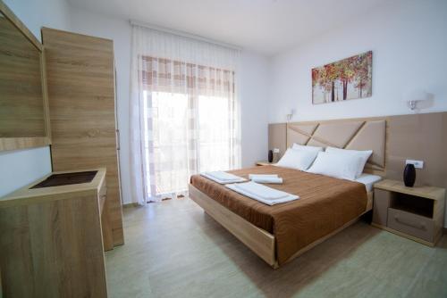 a bedroom with a large bed and a window at Kollari Apartments in Ulcinj