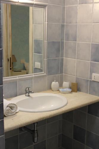 a bathroom with a sink and a mirror at Guest House Li Minnanni in Olbia