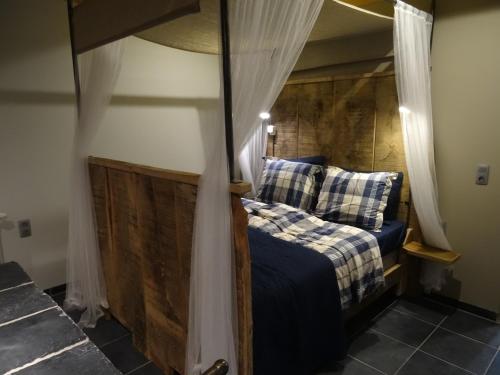 a bedroom with a bed with a canopy at Luxe kamer Cadzand in Cadzand