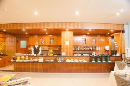 a man standing behind a counter in a restaurant at Convair Hotel in Ciudad del Este