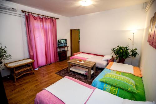 a living room with two beds and a table at Apartman Oaza in Trebinje