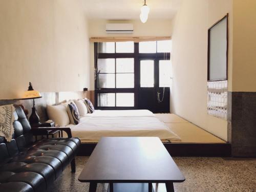 a hotel room with a bed and a couch at GOIN Old House & Bar in Tainan