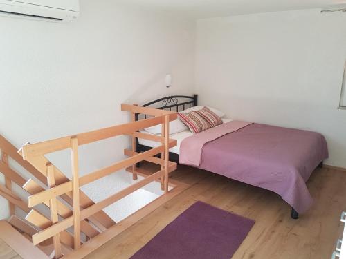 a small bedroom with a bed and a staircase at Apartment Lux Star in Milna