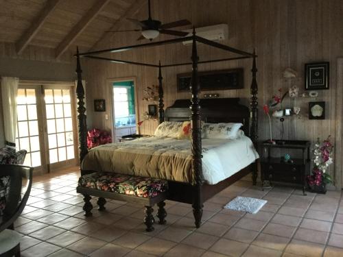 a bedroom with a canopy bed and a fan at Coconut Beach House in Green Turtle Cay