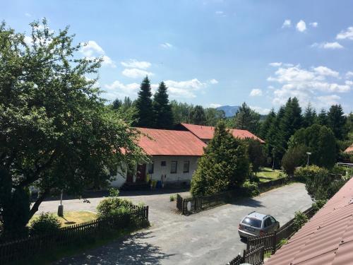 a house with a car parked in front of it at Penzion 103 in Železná Ruda