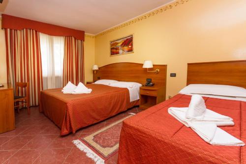 サウゼ・ドゥルクスにあるRelais Des Alpesのベッド2台と窓が備わるホテルルームです。