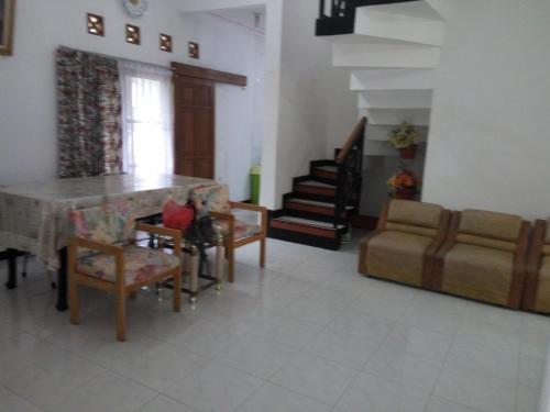 a living room with a table and chairs and a couch at Villa Ohana Batu in Batu