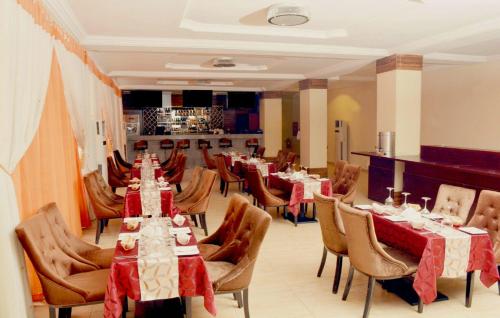 a dining room with tables and chairs in a restaurant at Sweet Spirit Hotel and Suites Danag - Port Harcourt in Port Harcourt