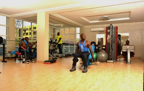 a man sitting in a gym sitting on a exercise ball at Sweet Spirit Hotel and Suites Danag - Port Harcourt in Port Harcourt