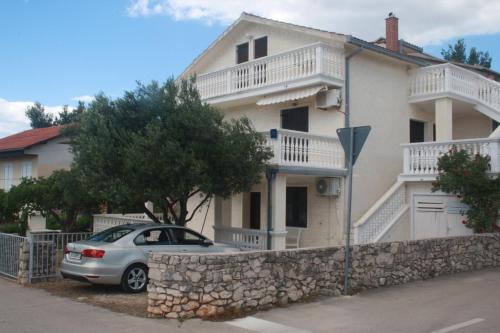 een auto geparkeerd voor een huis bij Apartments Vahovec Vodice in Vodice