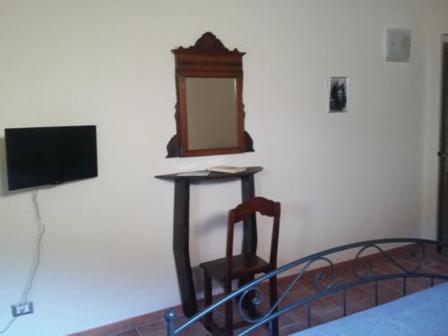 a bedroom with a mirror and a chair and a bed at Ca Giacomo in Tresana