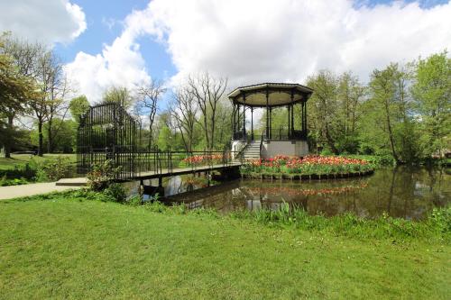 a bridge over a pond with flowers in a park at Guesthouse Prinsencanal 2 in Amsterdam