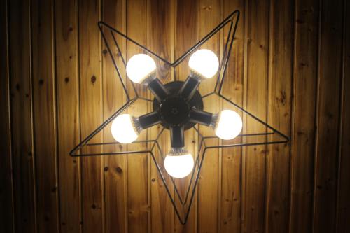 a ceiling fan with lights on a wooden wall at Moganshan Pinhouwu Hotel in Deqing