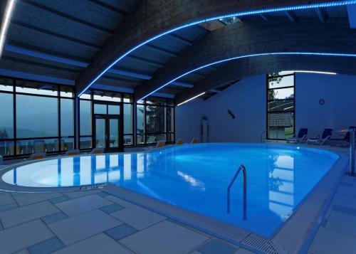 a large swimming pool in a building with windows at Osserhotel - B&B am Osser in Lohberg