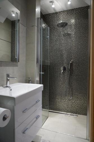 ソポトにあるHome3city Wakacyjnyのバスルーム(洗面台付きのシャワー、ガラス張りのシャワードア付)
