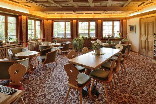 a restaurant with tables and chairs and windows at Hotel Corvatsch - Web Check-in in St. Moritz