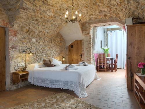 a bedroom with a bed in a stone wall at Can Barrull-Costa Brava-Emporda in San Felíu de Boada