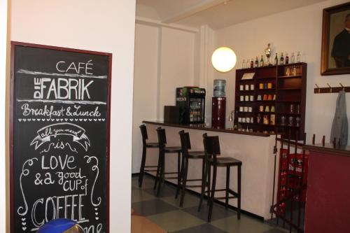 a bar with a chalkboard sign in a restaurant at Die Fabrik - Hostel in Berlin