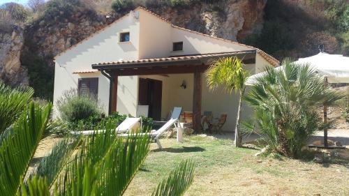 a small white house in front of a mountain at Agave Scopello in Scopello