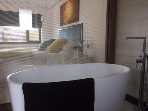 a white bath tub in a bathroom with a window at Antrim House Guest Rooms & Suites in Portrush