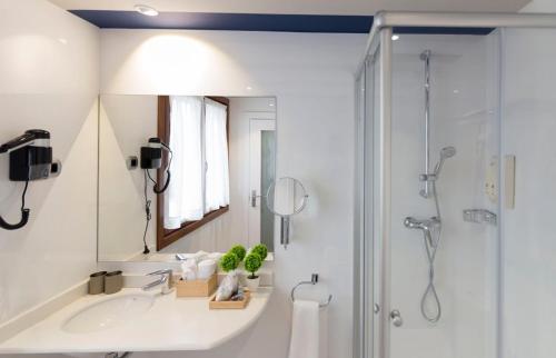 a bathroom with a sink and a shower with a mirror at Hotel Boutique Bahía de Plentzia in Plentzia