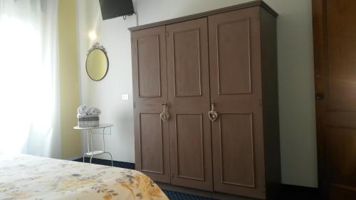 a bedroom with a large wooden cabinet next to a bed at Albergo al Sole in Val di Zoldo