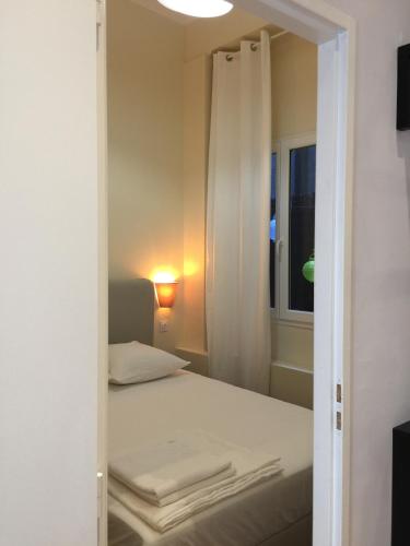 Cette chambre comprend un lit et une fenêtre avec des serviettes. dans l'établissement Cœur de ville grand-rue Jean Moulin, à Montpellier