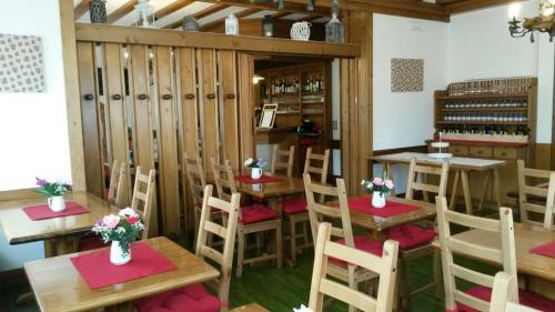 ein Restaurant mit Holztischen und -stühlen in einem Zimmer in der Unterkunft Albergo al Sole in Val di Zoldo