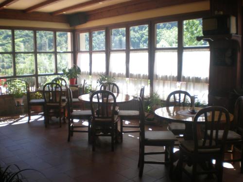 un comedor con mesas, sillas y ventanas en Hotel Bellavista Ordesa en Torla