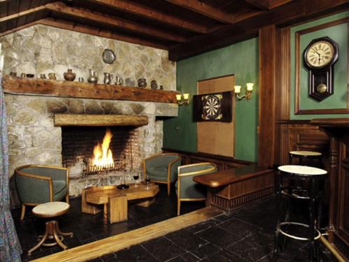a room with a fireplace and a table and chairs at Apart Hotel La Bora in San Martín de los Andes