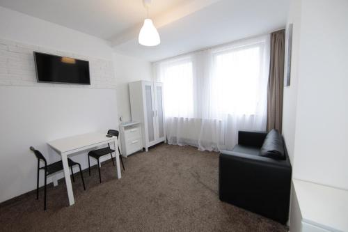 a living room with a couch and a table and a tv at Willa Park Międzyzdroje in Międzyzdroje