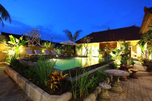 a swimming pool in a resort at night at Bali Sunshine Ubud in Ubud