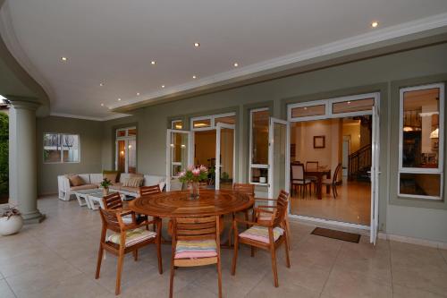 a dining room with a table and chairs at Sandown Guest House in Johannesburg