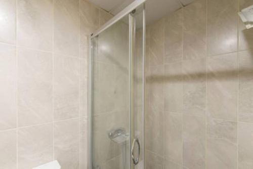 a shower with a glass door in a bathroom at The Tuyap Rainbow Suites in Beylikduzu
