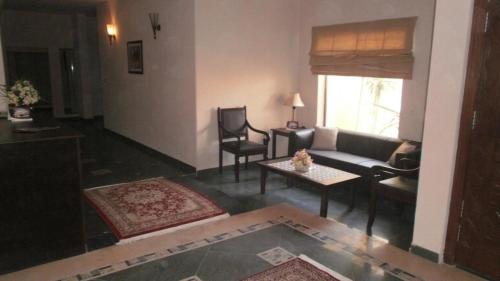 a living room with a couch and a table at Hotel One Bahawalpur in Bahawalpur
