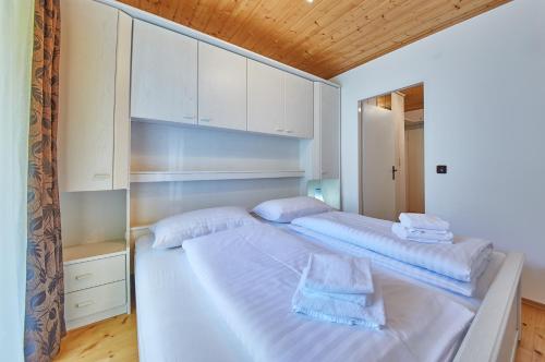 ザールバッハ・ヒンターグレムにあるAppartement Snow Queenのベッドルーム(ベッド2台、白いキャビネット付)