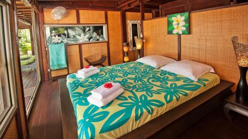 1 dormitorio con 1 cama con toallas en Robinson's Cove Villas - Deluxe Wallis Villa, en Papetoai