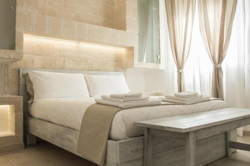 1 dormitorio con 1 cama con 2 toallas en Bed & Breakfast AMATI, en Fasano