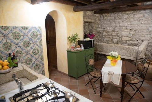 a kitchen with a stove and a table with a tableablish at Appartamenti Liberty in Erice