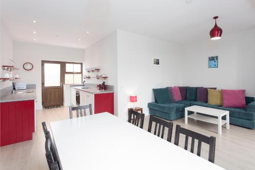 a kitchen and a living room with a table and chairs at Garryvoe Beach Homes in Garryvoe