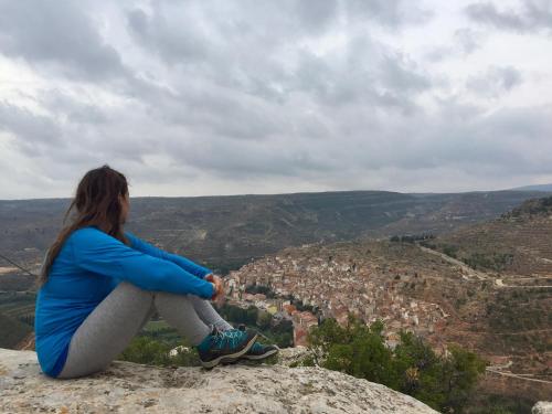 a woman sitting on a rock looking at a city at Casa Rural Garrido in Ademuz