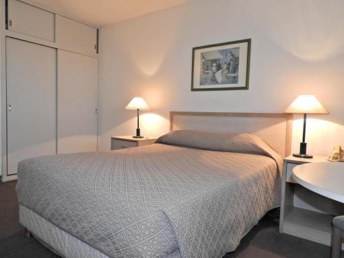 a bedroom with a bed and two lamps and a sink at Hotel Tres Cruces in Montevideo