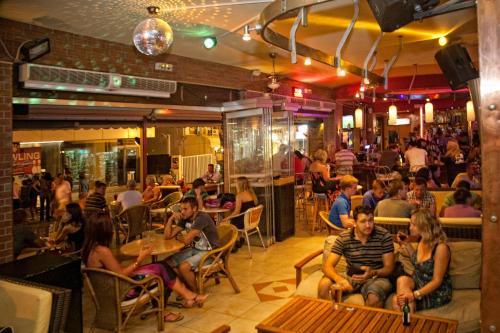 a group of people sitting in a restaurant at Rea Hotel in Faliraki
