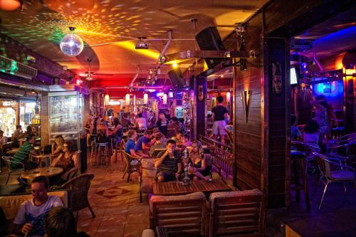 a group of people sitting in a bar at Rea Hotel in Faliraki