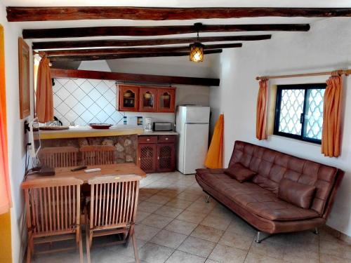 a living room with a couch and a kitchen at Nature Beach Resort Quinta Al-Gharb in Vila do Bispo