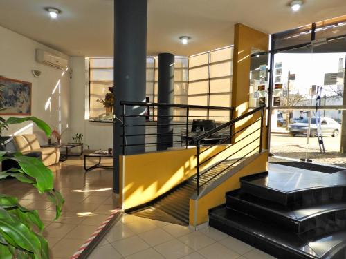 a lobby with a yellow and black staircase in a building at Hotel Tres Cruces in Montevideo